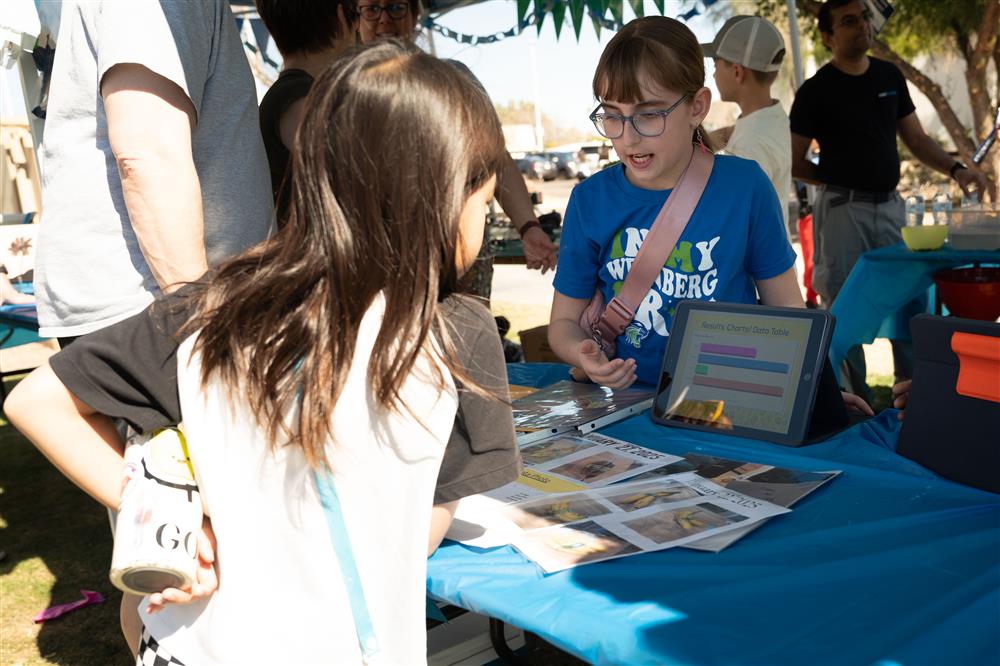 An image of a Weinberg Gifted Academy student showcasing her science project.